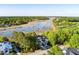 An aerial view of a beautiful home nestled among trees near a river with multiple docks and recreational water access at 3600 Henrietta Hartford Rd, Mount Pleasant, SC 29466