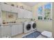 Bright laundry room with white cabinetry, sink, and modern washer and dryer units at 3600 Henrietta Hartford Rd, Mount Pleasant, SC 29466