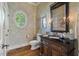 Elegant powder room with unique finishes, oval window, and wood accents at 3600 Henrietta Hartford Rd, Mount Pleasant, SC 29466