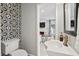 Stylish powder room features a modern sink, patterned tile wall, and a glimpse into the living area at 40 Grand Pavilion Blvd, Isle of Palms, SC 29451