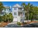Inviting two-story home featuring a garage, front porch, well-manicured lawn, and lush landscaping at 40 Grand Pavilion Blvd, Isle of Palms, SC 29451