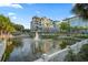 Exterior view of condos overlooking a lake with a fountain and lush landscaping at 40 Grand Pavilion Blvd, Isle of Palms, SC 29451