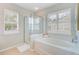 Bright bathroom featuring a glass-enclosed shower, soaking tub, and shuttered windows at 41 Regency Oaks Dr, Summerville, SC 29485