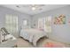 Bright bedroom featuring a cozy bed, ceiling fan, shutters, and neutral tones at 41 Regency Oaks Dr, Summerville, SC 29485