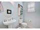 A stylish powder room features a pedestal sink, round mirror, and bright, neutral decor at 41 Regency Oaks Dr, Summerville, SC 29485