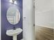 Powder room with blue accent wall, pedestal sink, updated faucet, lighting, and framed oval mirror at 4926 Lake Palmetto Ln, North Charleston, SC 29418