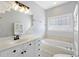 Well-lit bathroom with vanity, framed mirror, decorative light fixture, soaking tub, and tiled floor at 4926 Lake Palmetto Ln, North Charleston, SC 29418