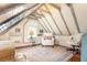 Bright attic bedroom showcases exposed beams, unique architecture, cozy seating area and natural light at 55 Laurens St # 55-A, Charleston, SC 29401