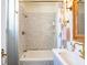 Bright bathroom with circle patterned tile surround, shower and tub combo, vintage-style faucet, and wicker mirror at 55 Laurens St # 55-A, Charleston, SC 29401