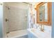 Elegant bathroom features stylish tilework, tub and shower combo, and a beautiful wicker-framed mirror at 55 Laurens St # 55-A, Charleston, SC 29401