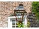 Exterior gas lamp fixture set against the backdrop of a brick wall and window at 55 Laurens St # 55-A, Charleston, SC 29401