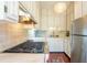 Galley kitchen features a stainless steel refrigerator, gas cooktop and stone countertops at 55 Laurens St # 55-A, Charleston, SC 29401