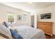 Bright main bedroom with a wall-mounted TV and windows overlooking the backyard at 55 Laurens St # 55-A, Charleston, SC 29401