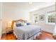 Bright main bedroom with hardwood floors, bedside tables, and windows overlooking the yard at 55 Laurens St # 55-A, Charleston, SC 29401