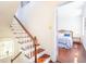Staircase leading to a bedroom with hardwood floors and a peek into a brightly lit bedroom with blue accents at 55 Laurens St # 55-A, Charleston, SC 29401