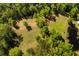 Aerial view of lush green property with mature trees, grassy area, and a serene pond at 5680 Dixie Plantation Rd, Hollywood, SC 29449