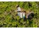 Aerial view of a property featuring a home, pool, and garden area surrounded by lush greenery and trees at 5680 Dixie Plantation Rd, Hollywood, SC 29449