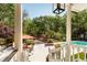 Covered porch view of the backyard oasis featuring a pool, outdoor lounge, and lush greenery at 5680 Dixie Plantation Rd, Hollywood, SC 29449
