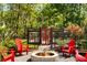 Outdoor space with red Adirondack chairs, a fire pit and a charming pergola with red doors at 5680 Dixie Plantation Rd, Hollywood, SC 29449
