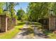 Gated driveway entrance with brick pillars and decorative iron gates providing privacy for the property at 5680 Dixie Plantation Rd, Hollywood, SC 29449