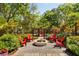 A welcoming outdoor fire pit area with red Adirondack chairs, perfect for relaxing and enjoying nature in this backyard at 5680 Dixie Plantation Rd, Hollywood, SC 29449
