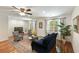 Cozy living room with hardwood floors, a blue sofa, patterned chairs, and ample natural light for relaxation at 5680 Dixie Plantation Rd, Hollywood, SC 29449