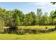 Scenic pond view with mature trees and lush green lawn in a serene natural setting at 5680 Dixie Plantation Rd, Hollywood, SC 29449