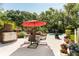 Backyard with pool, dining area with a red umbrella, brick grill, and lounge chairs at 5680 Dixie Plantation Rd, Hollywood, SC 29449