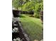 Lush backyard featuring manicured lawn, trees, flower beds, and a white picket fence at 5691 Captain Kidd Rd, Hollywood, SC 29449