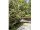 Landscaped backyard featuring a Bottlebrush tree, white fence, and charming outdoor seating area at 5691 Captain Kidd Rd, Hollywood, SC 29449