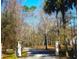 Community entrance with mature trees lining the drive and a stone and wrought iron gate at 5691 Captain Kidd Rd, Hollywood, SC 29449