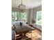 This bright dining room includes a wooden table under a hanging light fixture with large windows at 5691 Captain Kidd Rd, Hollywood, SC 29449