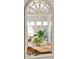 A sunlit dining room features a wooden table, rope chandelier and large windows with a view of the backyard at 5691 Captain Kidd Rd, Hollywood, SC 29449