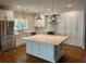 Modern kitchen with white cabinets, stainless steel appliances, a large island, and stylish pendant lighting at 5691 Captain Kidd Rd, Hollywood, SC 29449