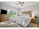 The bright bedroom features a ceiling fan, a large bed and an armchair at 5691 Captain Kidd Rd, Hollywood, SC 29449