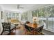 Bright sunroom featuring hardwood floors, oversized windows, ceiling fan and a comfortable seating area at 5691 Captain Kidd Rd, Hollywood, SC 29449