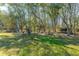 A backyard scene, full of trees, with a chicken coop on the right at 6440 St Anthony Dr, Hollywood, SC 29449