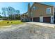 Exterior view of a two-story home featuring a balcony, three car garage and gravel driveway at 6440 St Anthony Dr, Hollywood, SC 29449