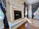 Close-up of a fireplace with decorative tiles, and elegant window treatments and hardwood floors at 6440 St Anthony Dr, Hollywood, SC 29449