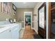 Inviting mudroom with laundry machines, hardwood floors, and a beautiful front door at 6440 St Anthony Dr, Hollywood, SC 29449