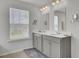 Bright bathroom with dual vanity, large mirrors, updated fixtures, and a window offering natural light at 648 Chigwell Springs Ln, Summerville, SC 29486