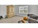 Bright bedroom offers a cozy seating area with plush chairs, window, and wooden armoire at 648 Chigwell Springs Ln, Summerville, SC 29486