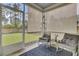 Relaxing screened porch with rocking chairs and a view of the fenced backyard at 648 Chigwell Springs Ln, Summerville, SC 29486