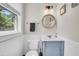 Cozy bathroom with a wood-trimmed mirror, bright lighting, and a light blue vanity at 733 Longfellow Rd, Charleston, SC 29407
