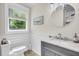 Bright half-bathroom with shiplap walls, gray vanity, and natural light at 733 Longfellow Rd, Charleston, SC 29407