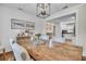 Open-concept dining area with white shiplap and artwork leading to the kitchen, with a rustic table at 733 Longfellow Rd, Charleston, SC 29407