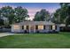 Charming brick home with a lush green lawn and inviting front porch with an orange colored front door at 733 Longfellow Rd, Charleston, SC 29407