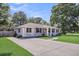 Charming brick home with a lush green lawn and inviting front porch with an orange colored front door at 733 Longfellow Rd, Charleston, SC 29407