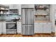 Bright kitchen with stainless steel appliances, open wood shelving, and a tile backsplash at 733 Longfellow Rd, Charleston, SC 29407