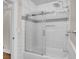 Modern shower-tub combo with white subway tile, a sliding glass door, and brushed metal fixtures at 733 Longfellow Rd, Charleston, SC 29407